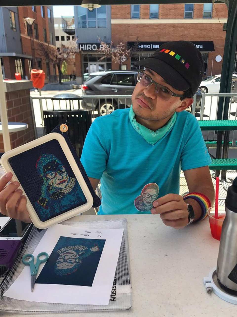 Justin Gibson holds an in-progress “RBG in RGB” cross stitch at a makers market in Lincoln, Nebraska