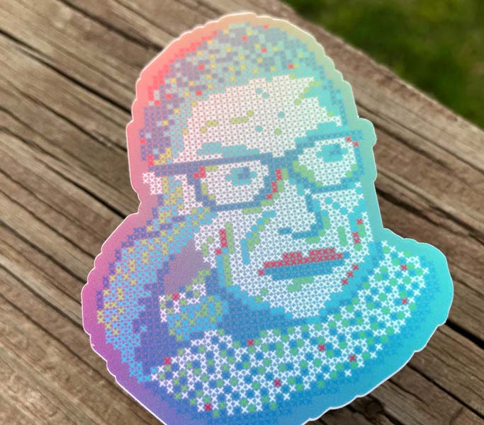Die-cut vinyl sticker of Ruth Bader Ginsburg (RBG) in colors red, green, and blue (RGB) on wooden texture