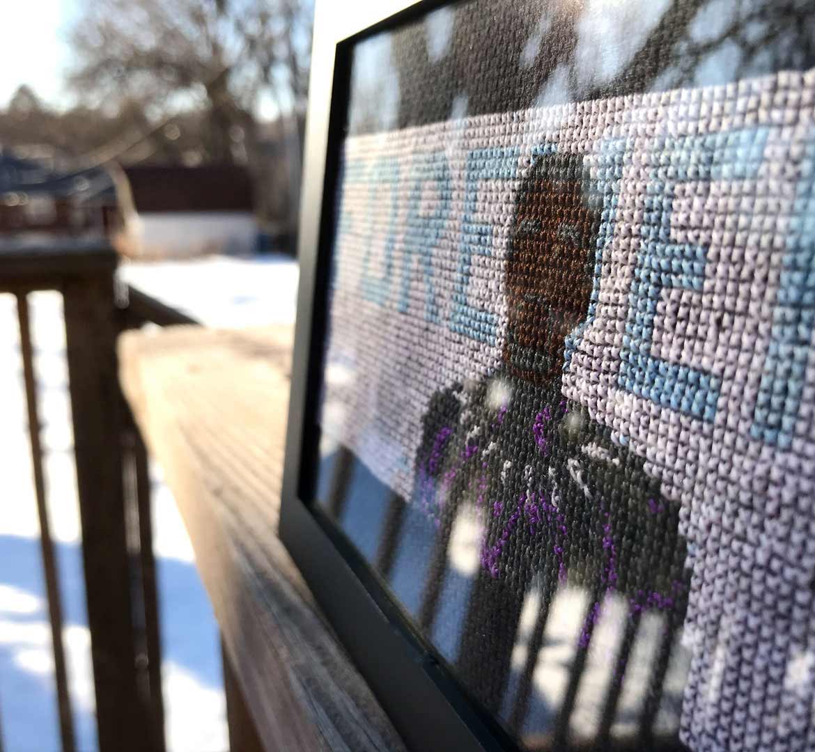 Framed cross stitch design of Chadwick Boseman as Black Panther with “FOREVER” flanking him in clouds